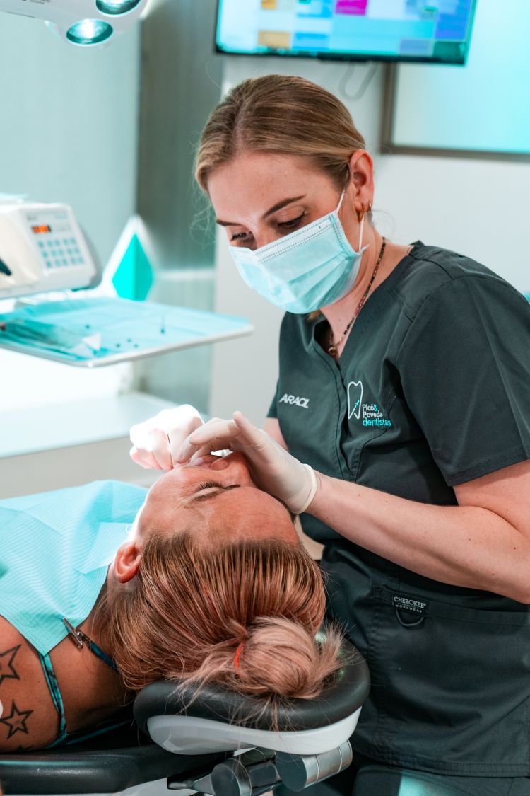 Dentista realizando una implantología a una paciente