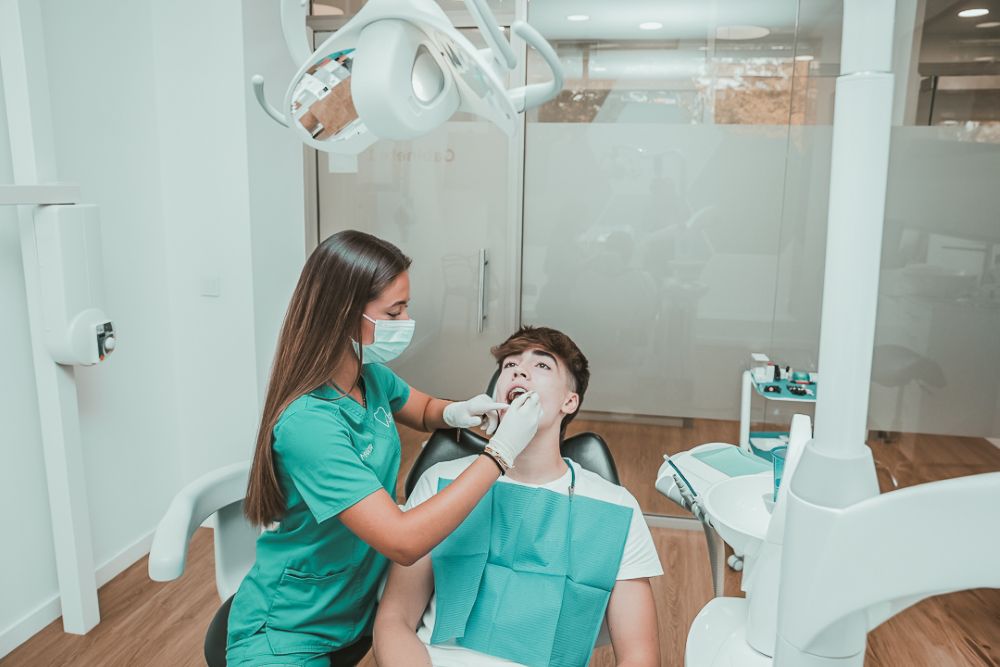 Dentista con un niño realizando un tratamiento odontopediatra
