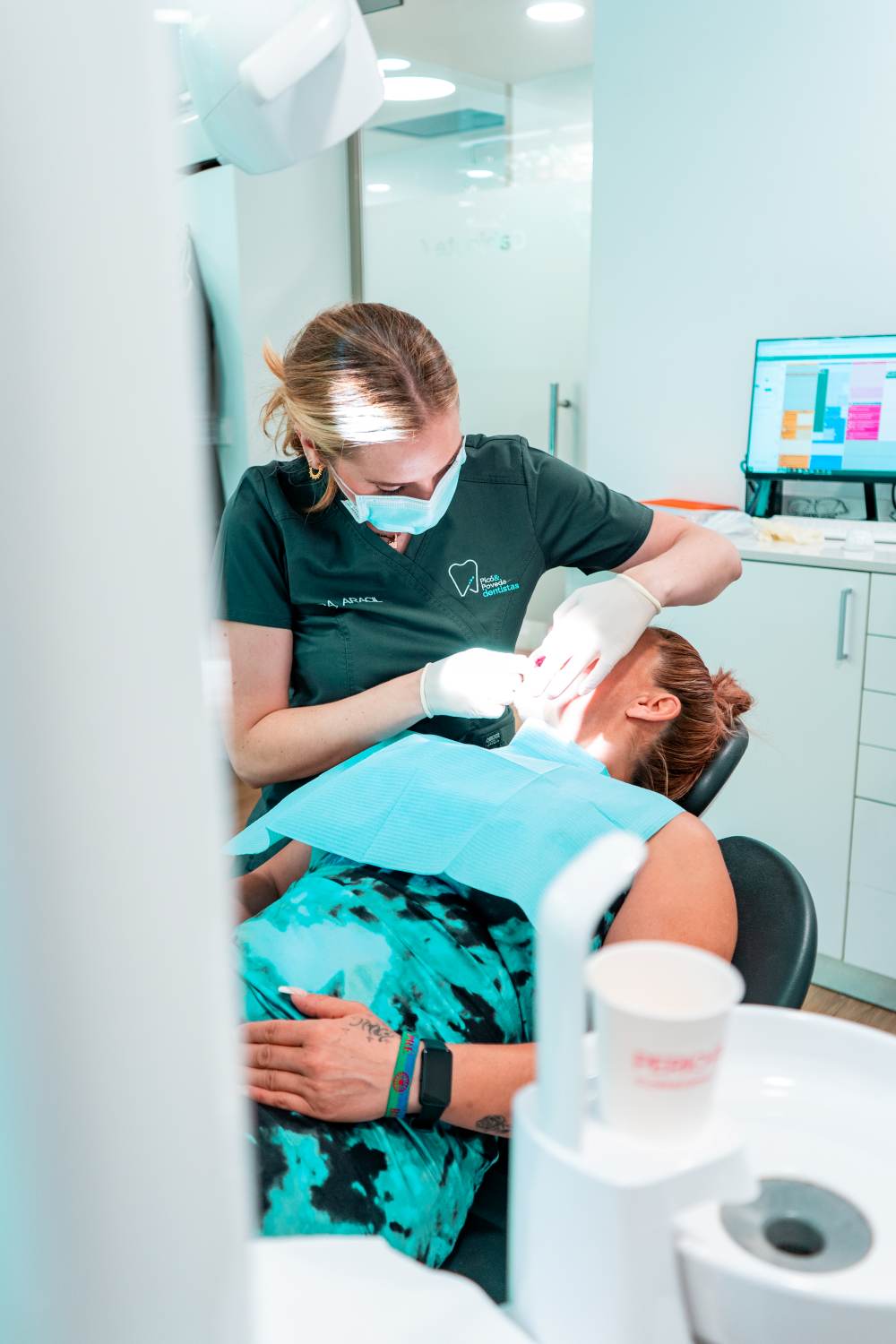 Dentista realizando una periodoncia a una paciente en Picó&Poveda