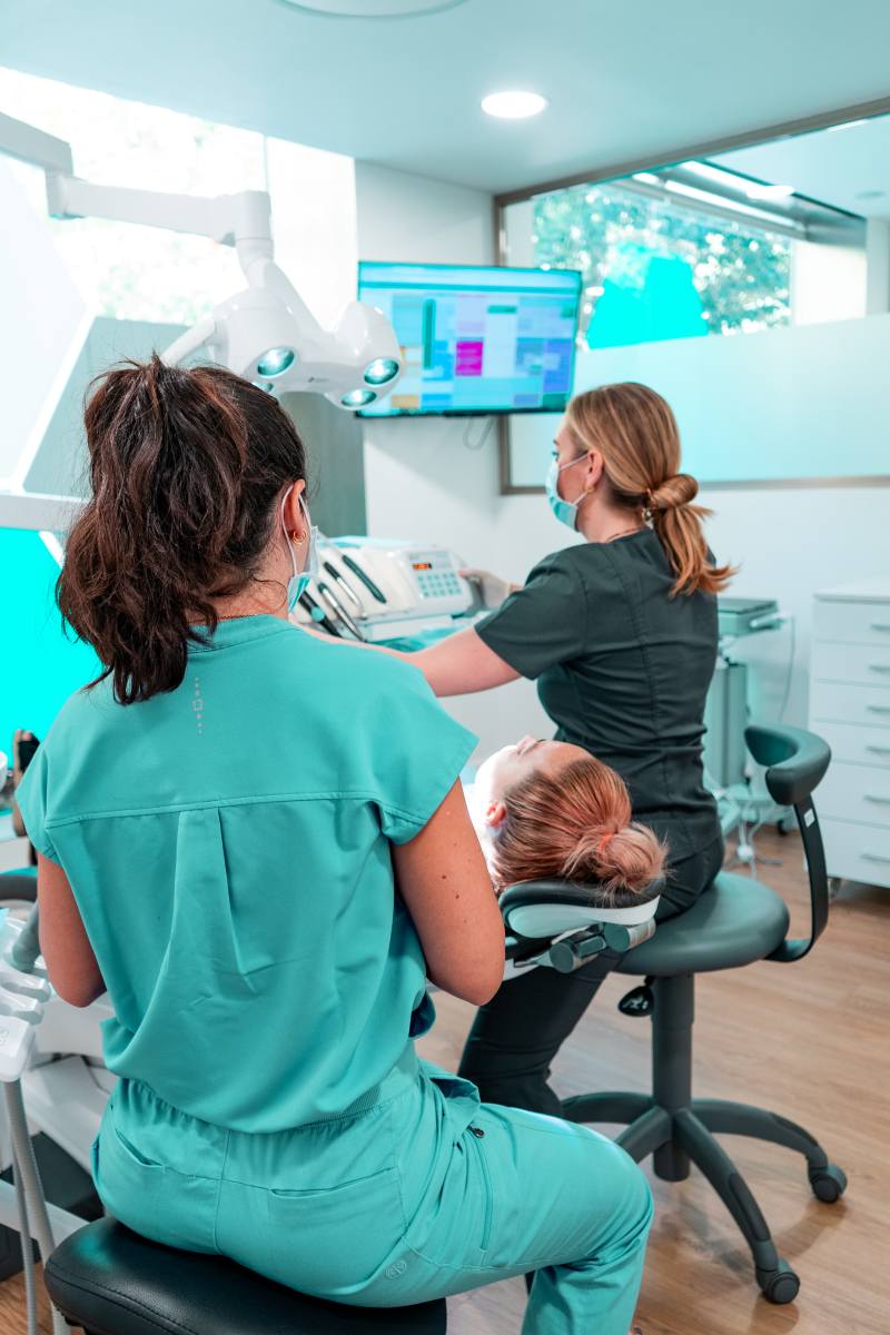 Dentistas aplicando prótesis dentales a un paciente en Picó&Poveda